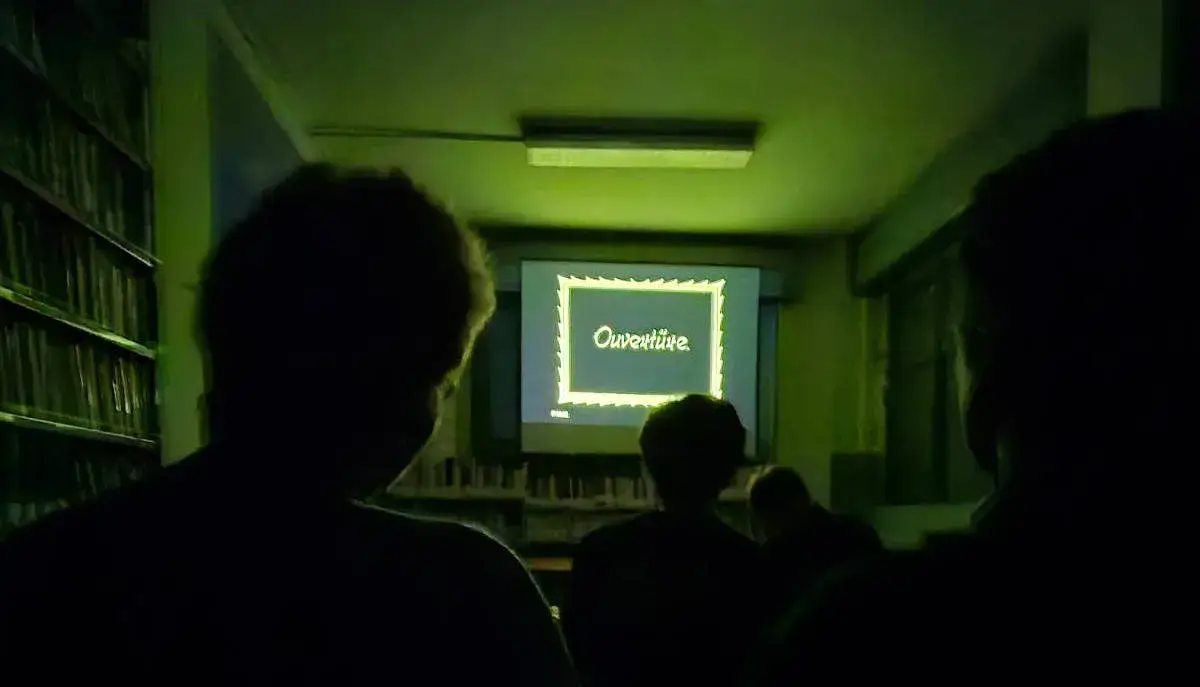 Immagine di una proiezione del cineforum: teste scure del pubblico si stagliano sopra ad un fermoimmagine del film Nosferatu, con la scritta "Ouverture"